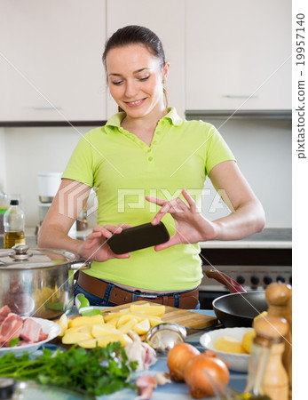 Housewife taking photo at kitchen. Housewife taking photo at kitchen. 19957140