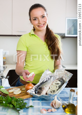 Woman cooking fish at home. 19957213