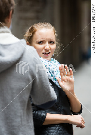 Couple having quarrel on city street 19957377
