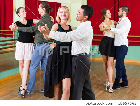 Three happy couples dancing tango 19957562