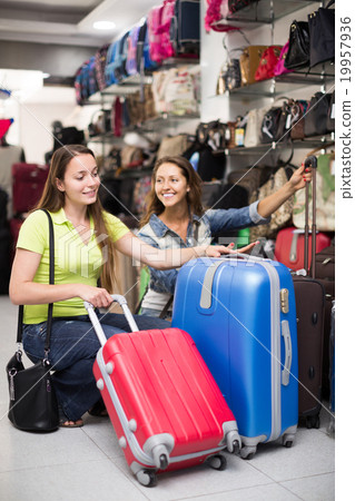 Woman choosing luggage bag in shop Woman choosing luggage bag in shop 19957936