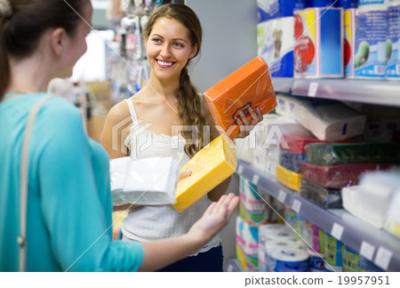 Young adults selecting napkins in store. 19957951