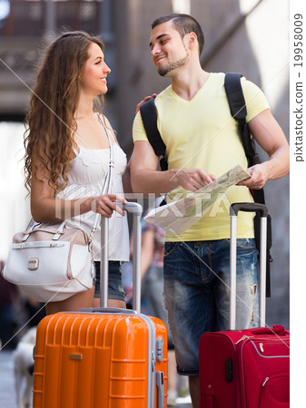 Couple with luggage reading map 19958009