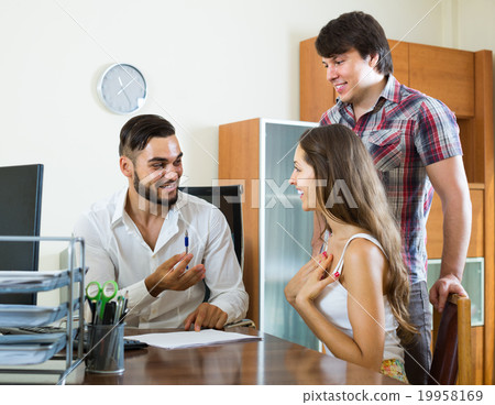 Couple and manager talking about purchase in the office 19958169