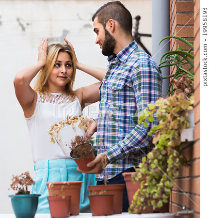 man making excuses for not watering girlfriends flowers 19958193