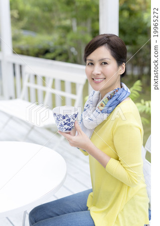 A woman in his forties who makes tea on the terrace A woman in his forties who makes tea on the terrace 19965272