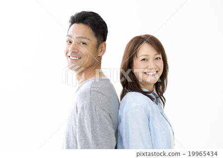 A couple standing back to back 19965434