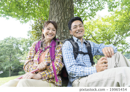 A couple sitting under a tree A couple sitting under a tree 19965454