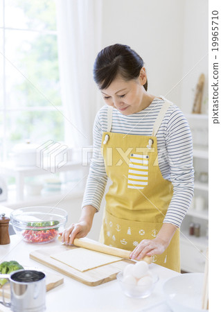 A Japanese woman standing in the kitchen 19965710