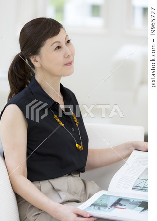 一個40多歲的女人拿著一本書 一個40多歲的女人拿著一本書 19965727