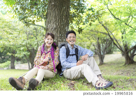 A couple sitting under a tree A couple sitting under a tree 19965816