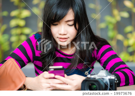 Young photographer woman using on mobile phone 19973676