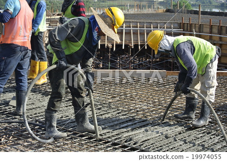 Construction Workers Using Concrete Vibrator 19974055