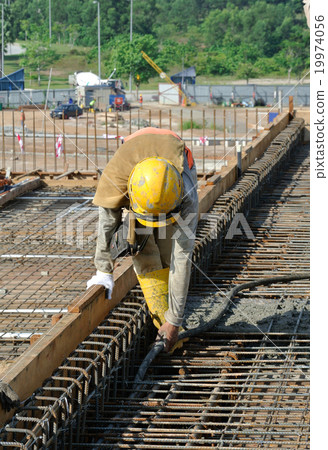 Construction Workers Using Concrete Vibrator 19974056