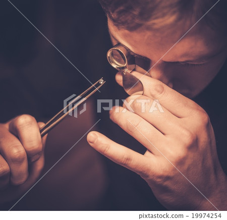 Portrait of a jeweler during the evaluation of jewels. Portrait of a jeweler during the evaluation of jewels. 19974254