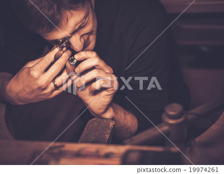 Portrait of a jeweler during the evaluation of jewels. Portrait of a jeweler during the evaluation of jewels. 19974261