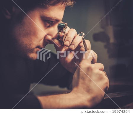 Portrait of a jeweler during the evaluation of jewels. Portrait of a jeweler during the evaluation of jewels. 19974264