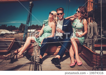 Stylish wealthy friends having fun on a luxury yacht Stylish wealthy friends having fun on a luxury yacht 19974316
