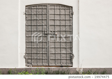 old iron shod gate of church in a white wall old iron shod gate of church in a white wall 19974475
