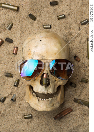 skull lying in the sand, scattered rifle and skull lying in the sand, scattered rifle and 19975168