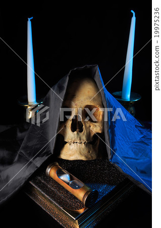 human skull on a book next to the clock. concept human skull on a book next to the clock. concept 19975236