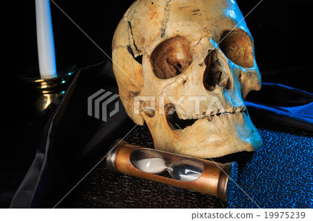 human skull on a book next to the clock. concept human skull on a book next to the clock. concept 19975239