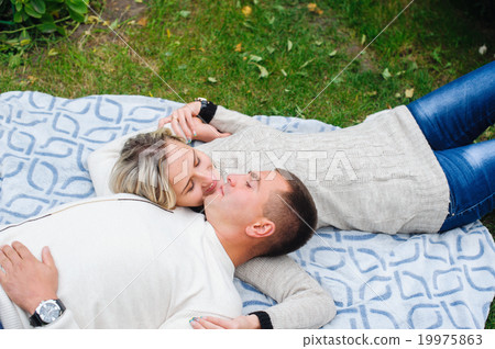 couple in love lying on the plaid in the park couple in love lying on the plaid in the park 19975863