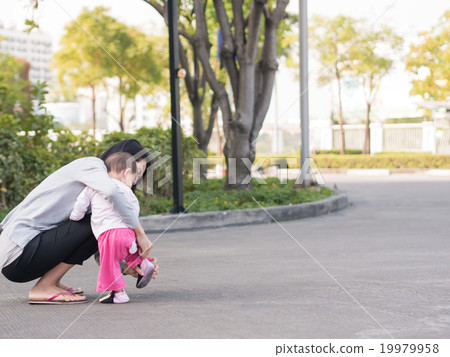 Asian mother help toddler wearing shoes. Asian mother help toddler wearing shoes. 19979958