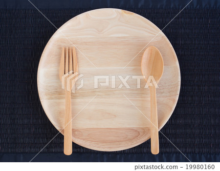 An empty wooden plate with wooden spoons and forks 19980160