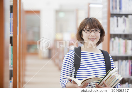 A woman looking for a book A woman looking for a book 19986237