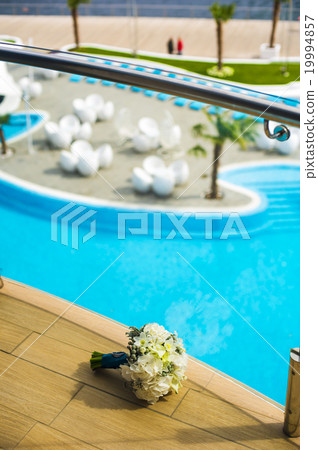 Bride's bouquet near the fencing. 19994857