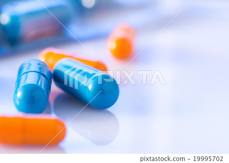Bunch of blue and orange coloured pills. Bunch of blue and orange coloured pills. 19995702