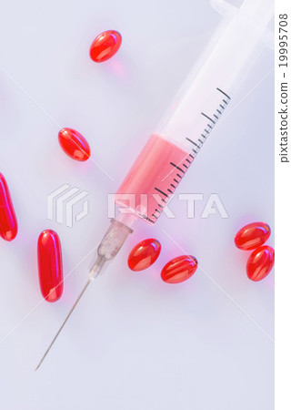Red pills and syringe on the surface. Red pills and syringe on the surface. 19995708