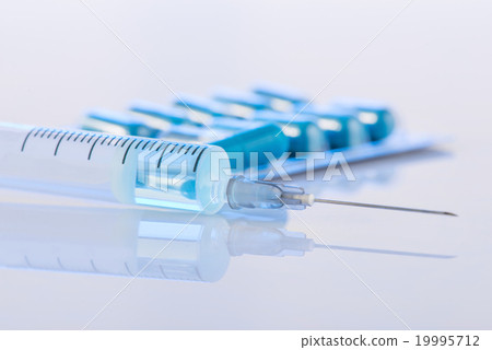Pack of pills and syringe are on the surface. Pack of pills and syringe are on the surface. 19995712