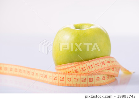 Apple and measuring tape on the surface. Apple and measuring tape on the surface. 19995742