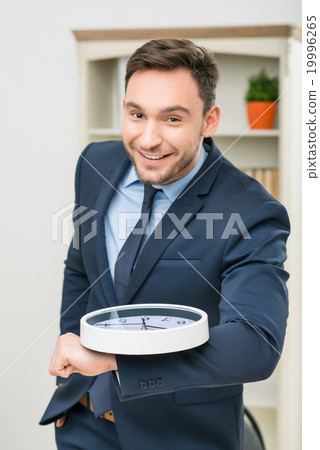 Pleasant office worker holding clock Pleasant office worker holding clock 19996265
