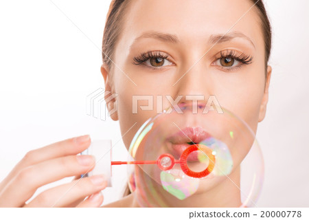 Young girl blowing out a soup bubble. 20000778