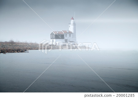 lighthouse in the fog is on the pier into the sea. mystical land lighthouse in the fog is on the pier into the sea. mystical land 20001285