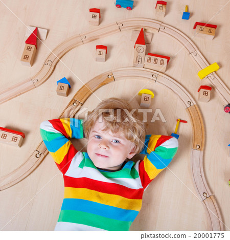 Little blond child playing with wooden railroad Little blond child playing with wooden railroad 20001775
