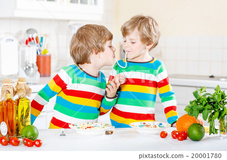 Two little kid boys eating spaghetti in domestic Two little kid boys eating spaghetti in domestic 20001780
