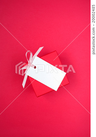 Gift box and empty tag with ribbon on the red 20002485