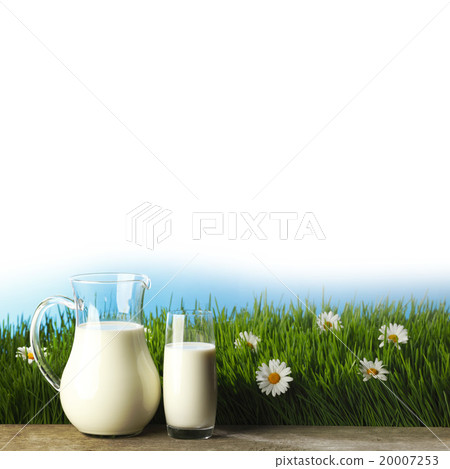 Glass of milk and jar on flower meadow 20007253