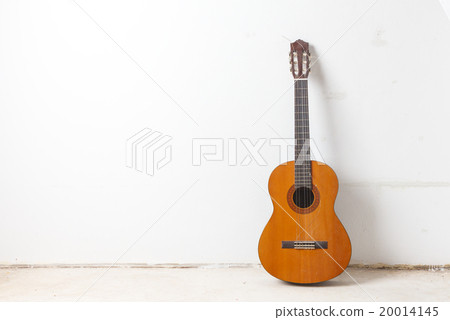 Old classical acoustic guitar on white wall background 20014145