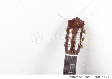 Old classical acoustic guitar on white wall background Old classical acoustic guitar on white wall background 20014174