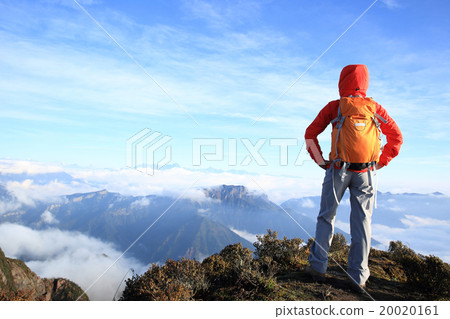 determined woman backpacker  on mountain peak 20020161