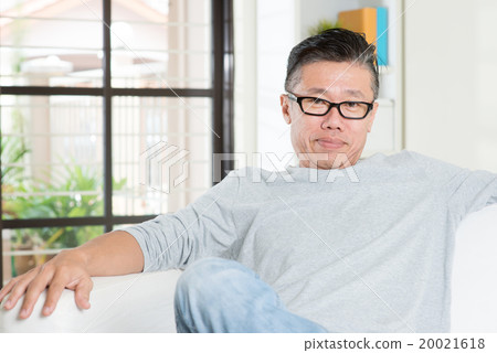 Mature 50s Asian man sitting at home. 20021618