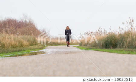 Young woman walking in a dutch landscape 20023513