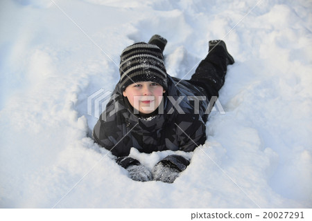 Teen boy lies on   snow in the winter forest 20027291