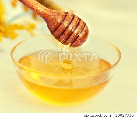 Honey and wooden spoon decorated with flowers 20027330