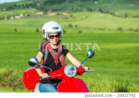 Young woman traveling by a scooter 20027792